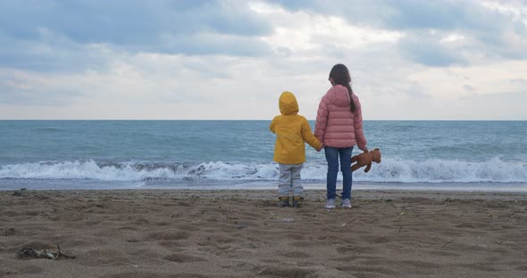 Little Children Playing on the Beach. Sister and Her Little Brother Holding Hands