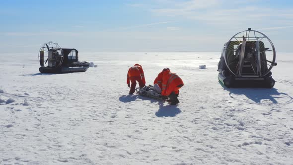 Rescuers Transporting Victim on Stretchers on Ice in Arctic alt