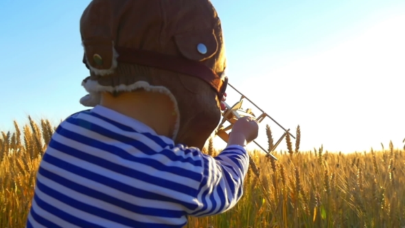 Happy Kid Playing with Toy Airplane Against Summer Sky Background alt