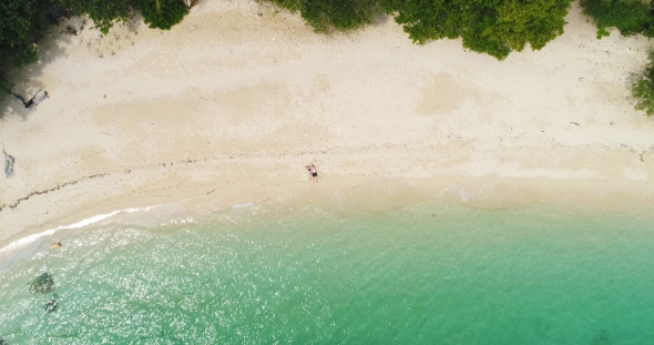 Aerial: A Loving Couple Lies Alone on the White Sand Deserted Beach.
