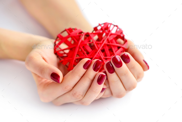 Wicker red heart in woman's hands on white background. Closeup h - Stock Photo - Images