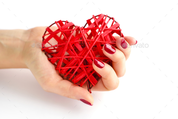 Wicker red heart in woman's hands on white background. Closeup h - Stock Photo - Images