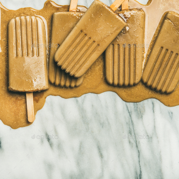 Flatlay of melting coffee latte popsicles, square crop - Stock Photo - Images