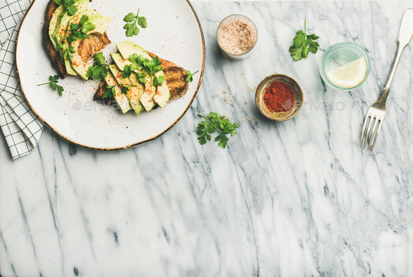 Flat-lay of avocado toast with seasoning - Stock Photo - Images
