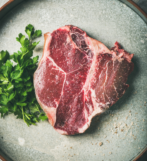 Flat-lay of raw uncooked dry-aged t-bone prime beef steak - Stock Photo - Images