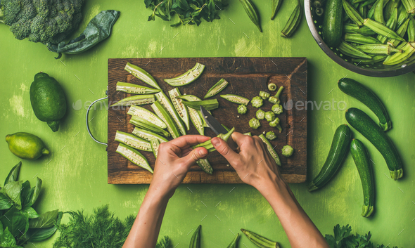 Flat-lay of healthy green vegan cooking ingredients over green background Stock Photo by sonyakamoz