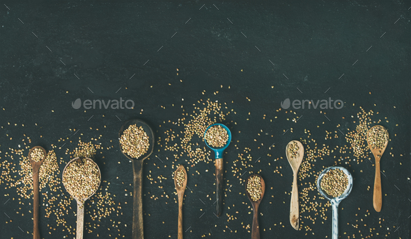 Various vintage kitchen spoons full of green buckwheat grains - Stock Photo - Images