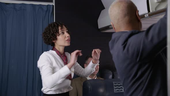 Flight attendant helps passengers board airplane