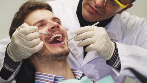 Handsome Young Man Smiling During Dental Examination alt
