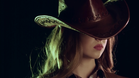 Sheriff Girl Holds a Revolver in Her Hands and Aiming at the Villain. Black Background. . alt