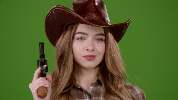 Sheriff Girl Holds a Revolver in Her Hands and Aiming at the Villain. Green Screen. alt
