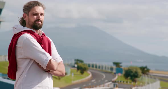 Man Folds His Arms While Observing Picturesque Scenery alt