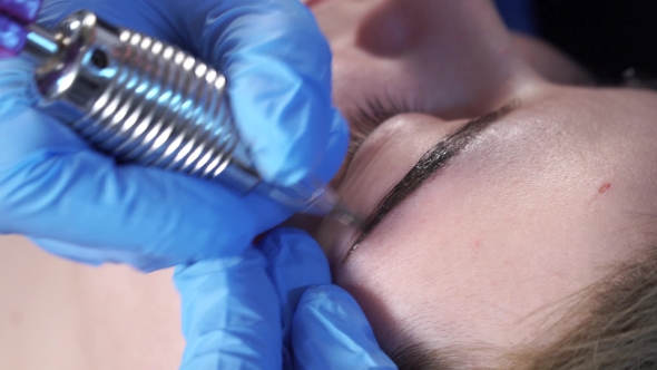 Beautician, Specialist of Permanent Make-up Is Applying Local Anesthetic Before the Eyebrows