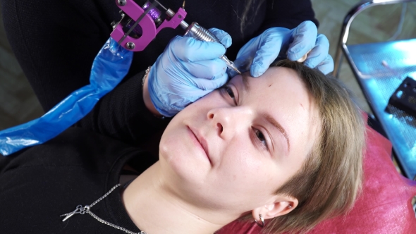 Beautician, Specialist of Permanent Make-up Is Applying Local Anesthetic Before the Eyebrows