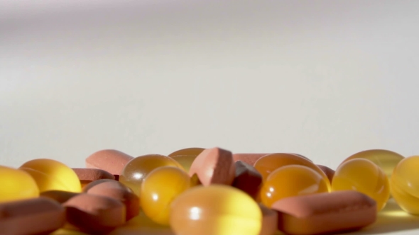 Pills Falling on White Background 