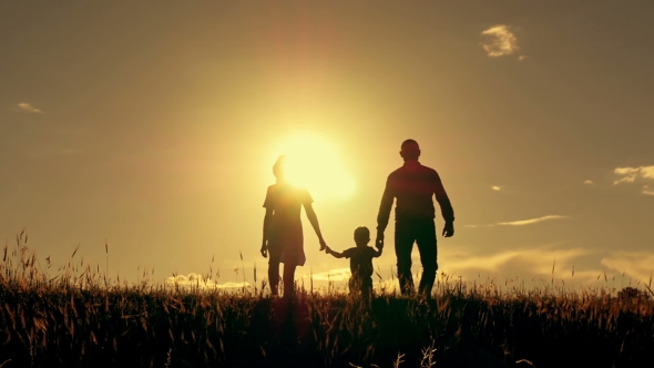 Silhouette of Mother and Father Walking with Their Child at Sunset ...