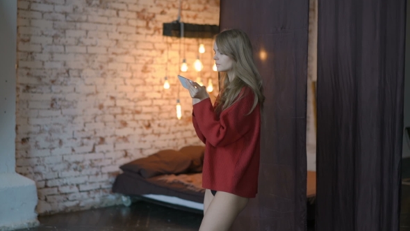 Young Girl Using Her Smartphone at Home in the Living Room for Chat with Her Friends