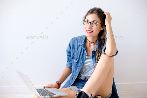 Smiling beautiful girl in glasses with laptop studio shot - Stock Photo - Images