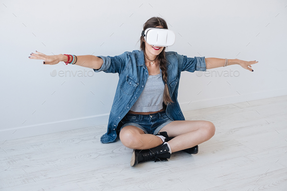 Flying girl while using VR glasses - Stock Photo - Images
