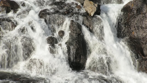 Rapid Stream of Mountain River Is Flowing over Hard Rocks and Creating Small Waterfalls