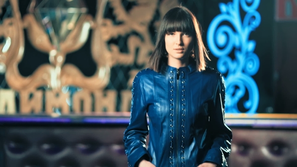 Young Fashion Woman in Leather Jacket Walking in Night Club alt