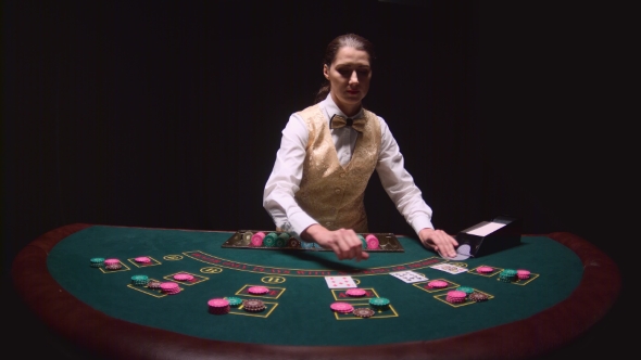 Casino Dealer Pulls Cards From Card Holder Lays Chips At A Poker Table Black Background Kinomaster