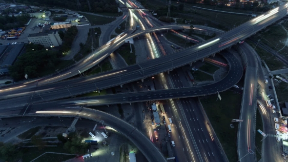 Overhead Flyover the Complex Road Junction Highway. Night Light, Sunset. High Altitude Drone Flight.