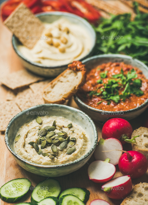 Vegetarian dips hummus, babaganush, muhammara over wooden background - Stock Photo - Images