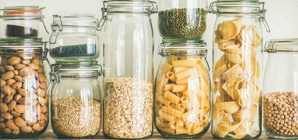 Uncooked cereals, grains, beans and pasta on rustic table, close-up - Stock Photo - Images