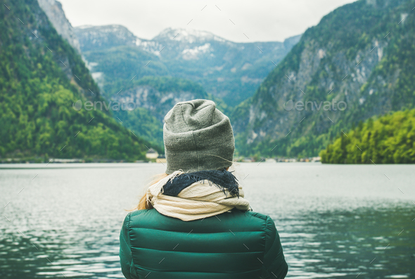 Female traveller standing at mountain lake coast in the Alps - Stock Photo - Images