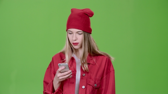 Teenager Looks at the Pictures in the Phone and Shows a Thumbs Up. Green Screen alt