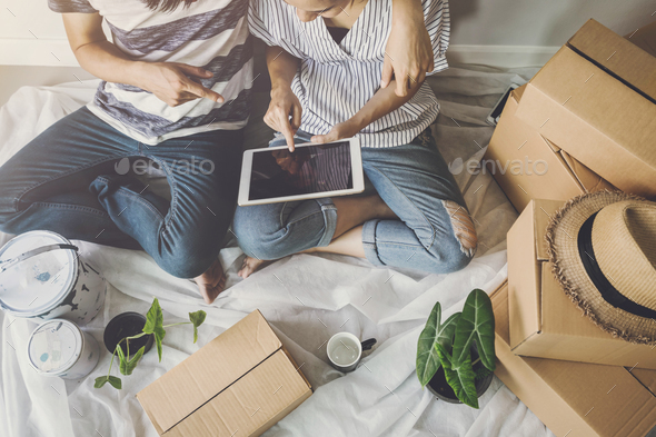 Young happy couple moving in new home, sitting and relaxing on the floor Stock Photo by kitzstocker