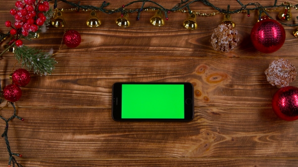 Smartphone Is on the Table, Next To the New Year's Lights. Top View alt