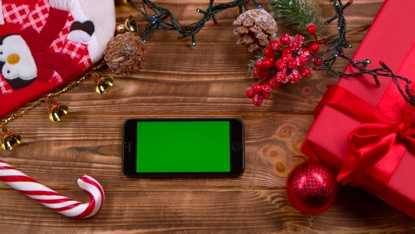 Man's Hand Puts the Phone on the Table, Garlands Burn. Top View alt