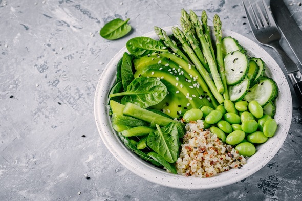Green vegetarian bowl salad with quinoa, spinach, avocado, asparagus, cucumber, edamame - Stock Photo - Images