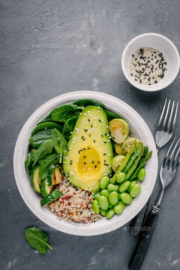 Green bowl lunch with quinoa, spinach, avocado, brussels sprouts, zucchini, asparagus, edamame - Stock Photo - Images