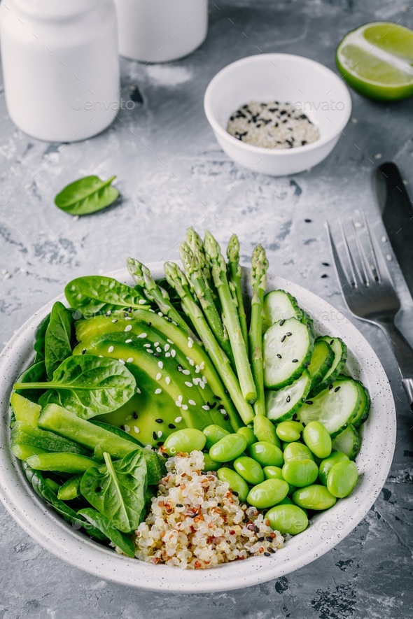 Green vegetarian bowl salad with quinoa, spinach, avocado, asparagus, cucumber, edamame - Stock Photo - Images