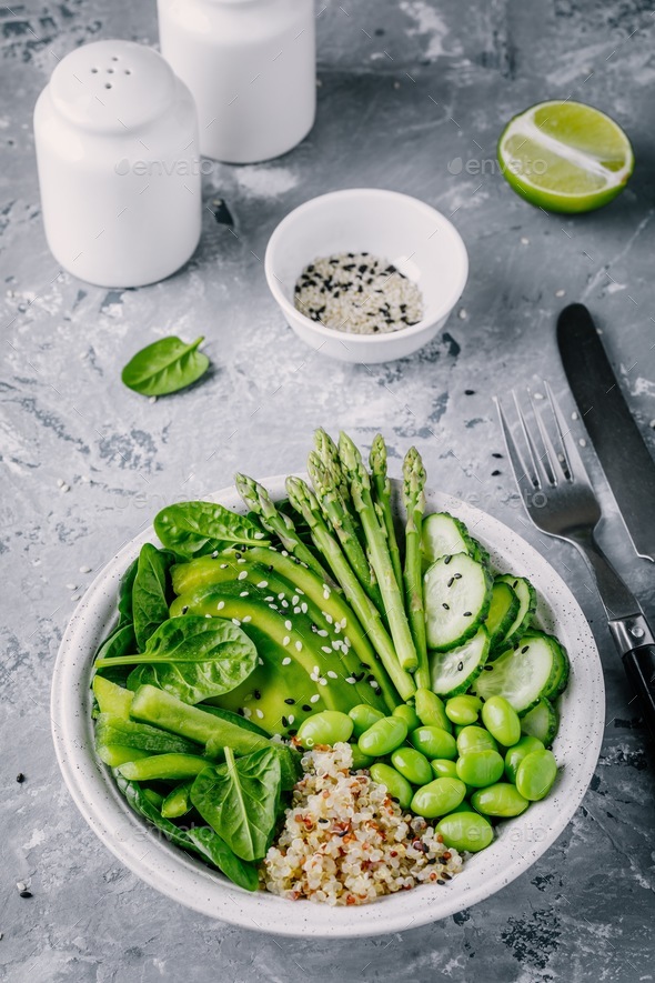 Green vegetarian bowl salad with quinoa, spinach, avocado, asparagus, cucumber, edamame - Stock Photo - Images