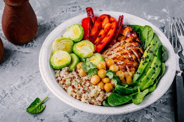 Vegetable bowl with grilled chicken and quinoa, spinach, avocado, brussels sprouts, chickpea Stock Photo by nblxer