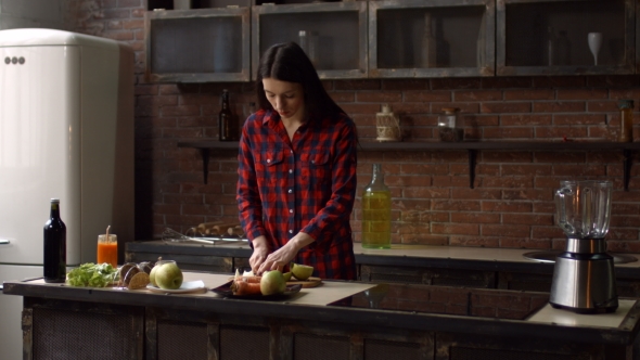 Beautiful Woman Slicing Apple on Cutting Board alt