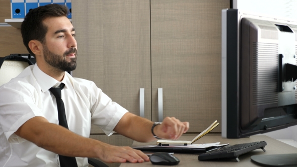 Young Attractive Businessman Relaxing at His Desk in the Office alt