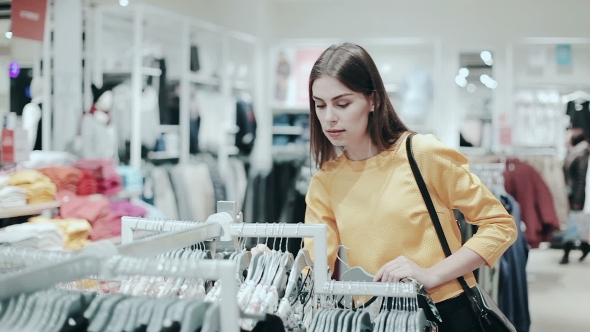 Woman Looking at Clothes on Rail in Clothing Store
