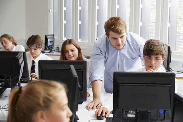 Teenage Students Wearing Uniform Studying In IT Class Stock Photo by monkeybusiness