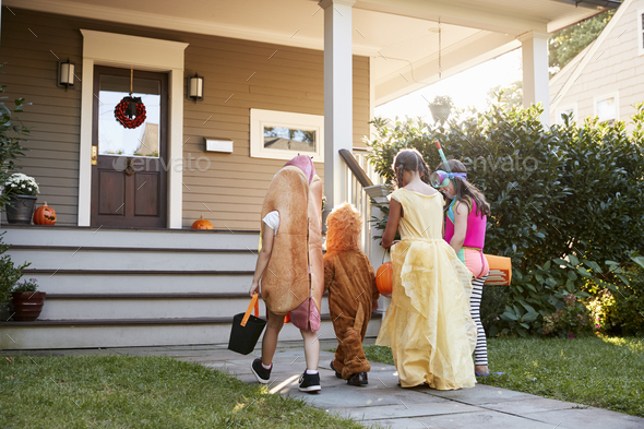 Children Wearing Halloween Costumes For Trick Or Treating Stock Photo by monkeybusiness