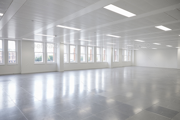 Vacant open plan office space with windows Stock Photo by monkeybusiness