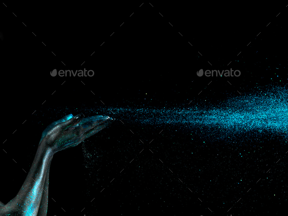 glitter falling from woman's hands black background