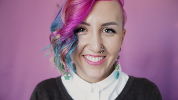 of Attractive Young Teenage Girl with Pink Hair Smiling at Camera