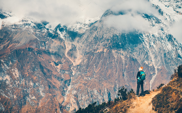 Woman with backpack on the path and mountains - Stock Photo - Images