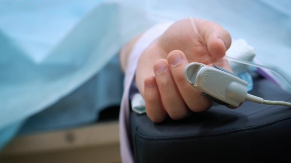 Patient's Hand in Bed with Oximeter. Resuscitate the Patient, Measure the Pulse and Pressure