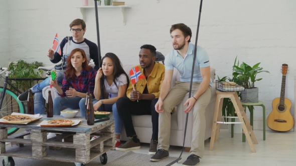 Group of Young Friends Sports Fans with Norwegian National Flags Watching Sport Championship on TV alt
